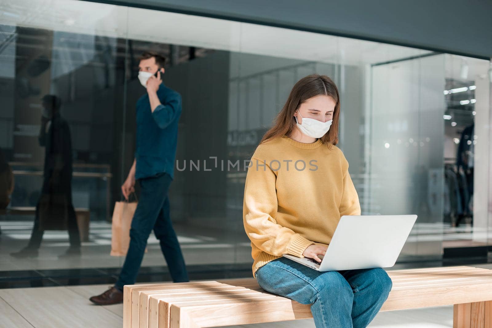 young woman using her laptop on the street during quarantine . concept of health protection
