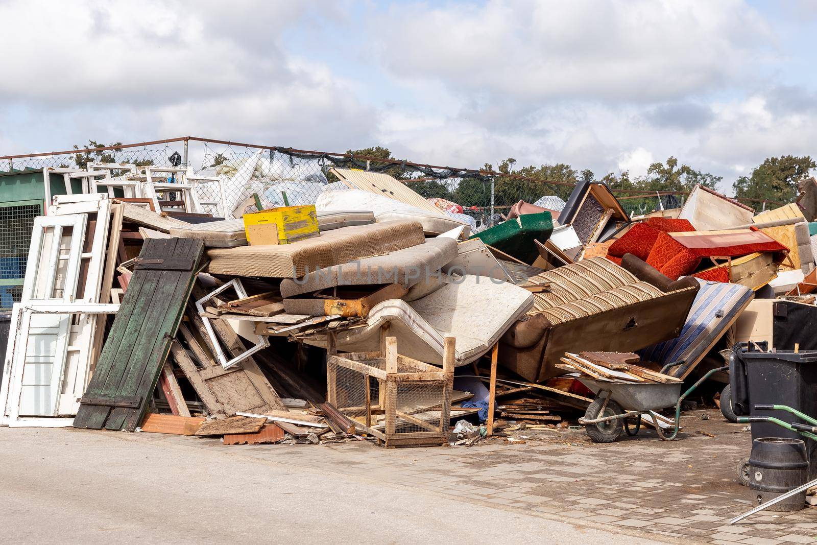 Recycling dump with trash of broken window and door frames, furniture, sofas, chairs and more