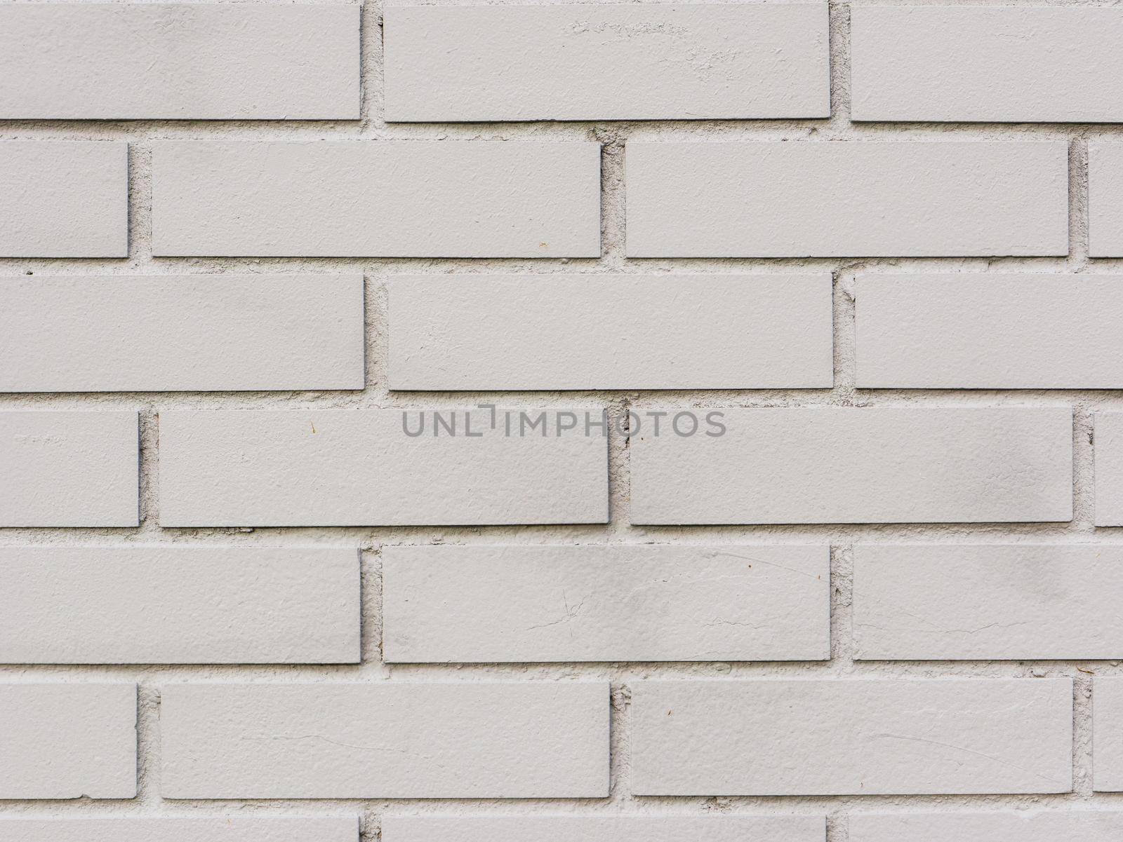 Painted brick wall and weathered sidewalk.