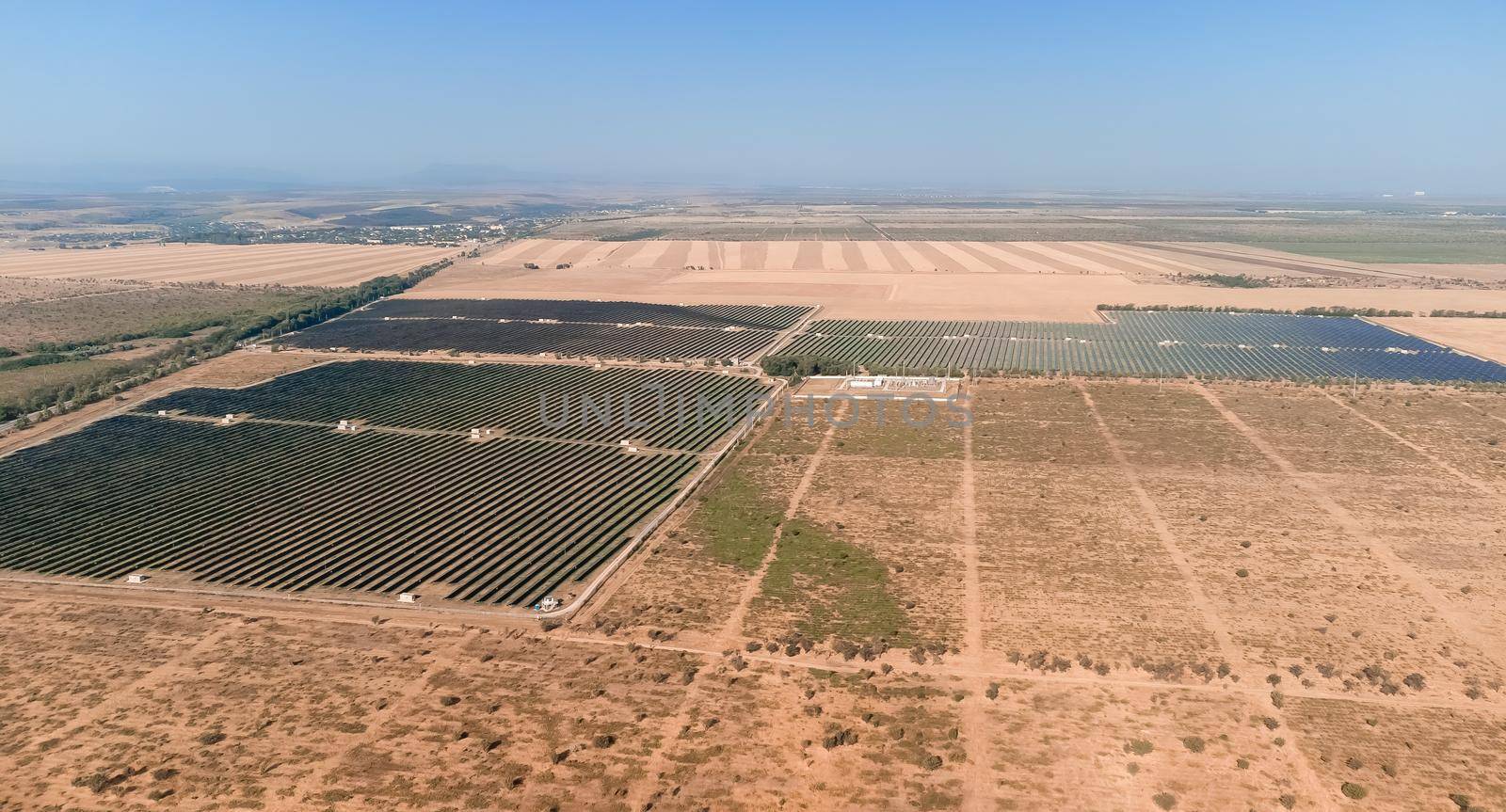 Aerial top view of a solar panels power plant. Photovoltaic solar panels at sunrise and sunset in countryside from above. Modern technology, climate care, earth saving, renewable energy concept
