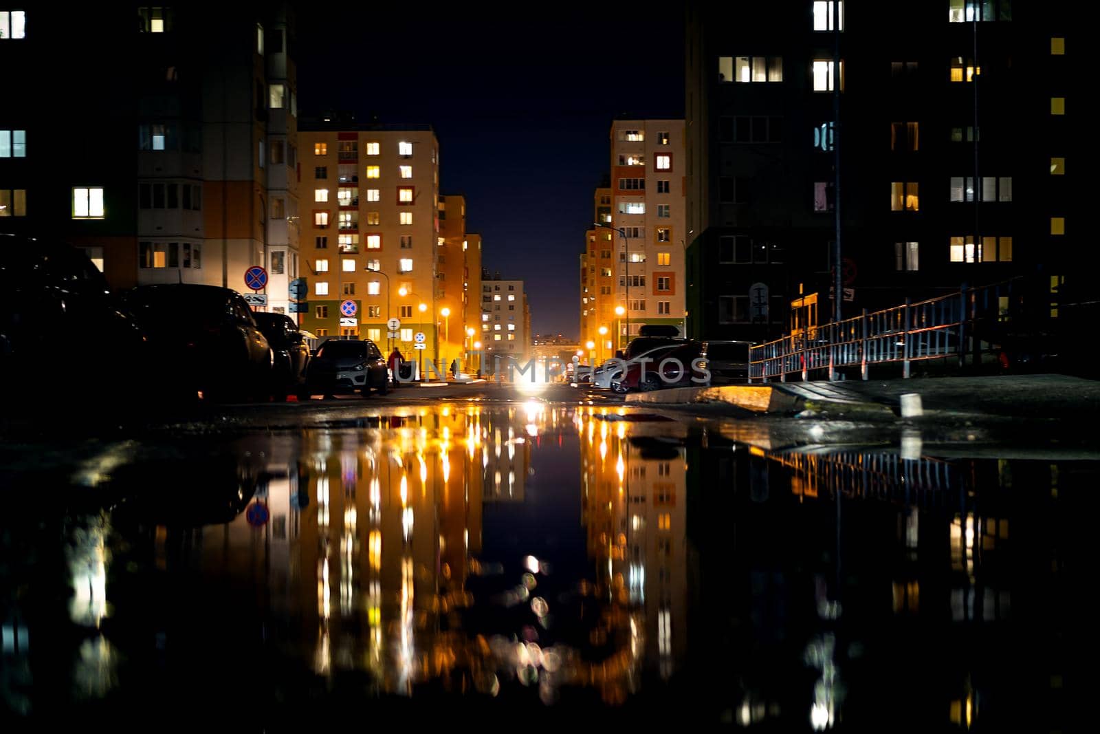 Night life, modern buildings of the capital with the reflection of light in puddles. Urban landscape, on a rainy day.