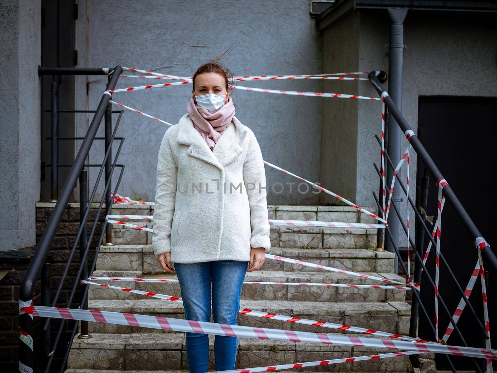 Photo of a girl in a mask. Standing on the street with danger warning tapes. isolated Covid-19 pandemic.