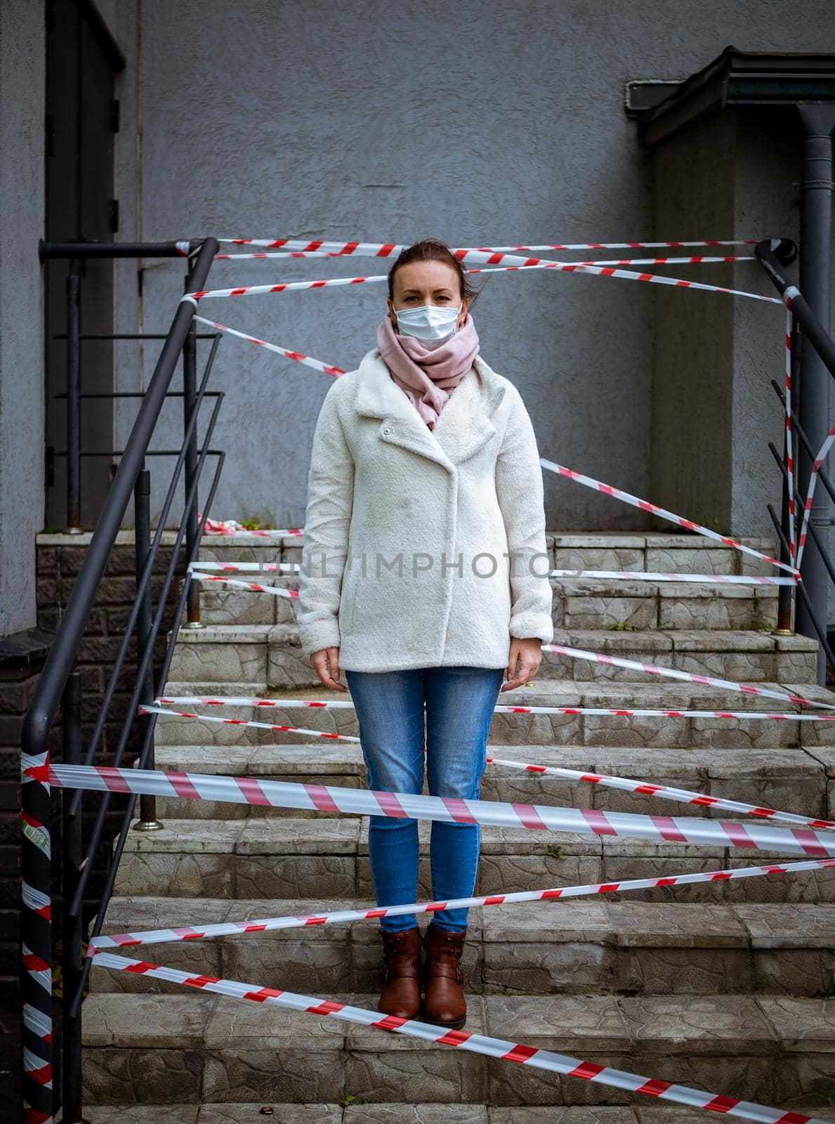 Photo of a girl in a mask. Standing on the street with danger warning tapes. isolated Covid-19 pandemic.