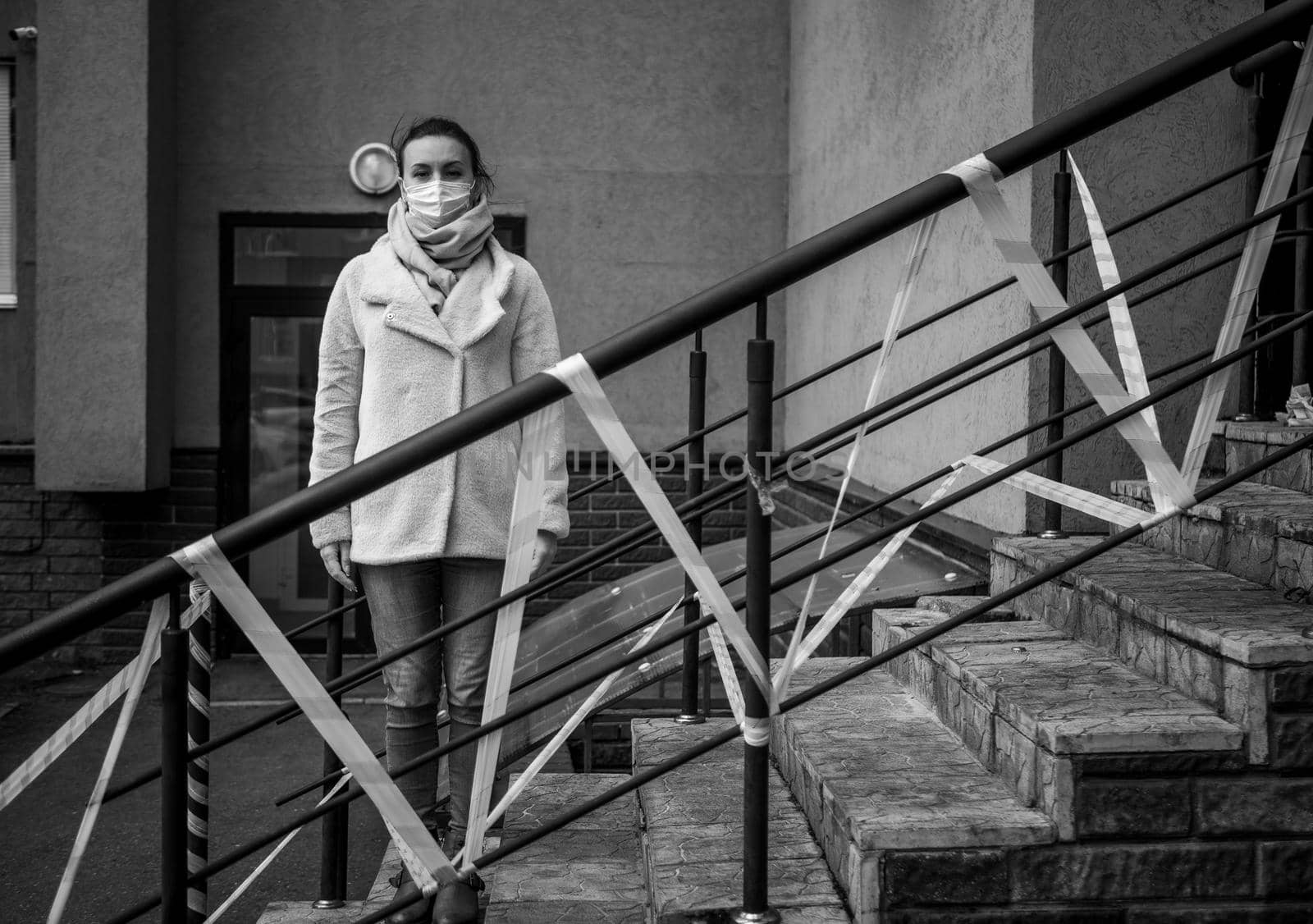 Photo of a girl in a mask. Standing on the street with danger warning tapes. isolated Covid-19 pandemic.