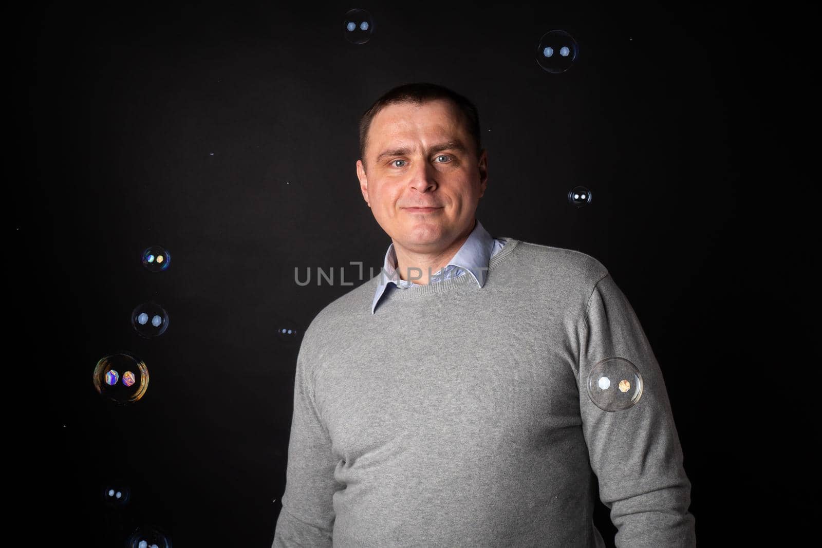 handsome businessman in a suit looks at the camera. isolated on a black background