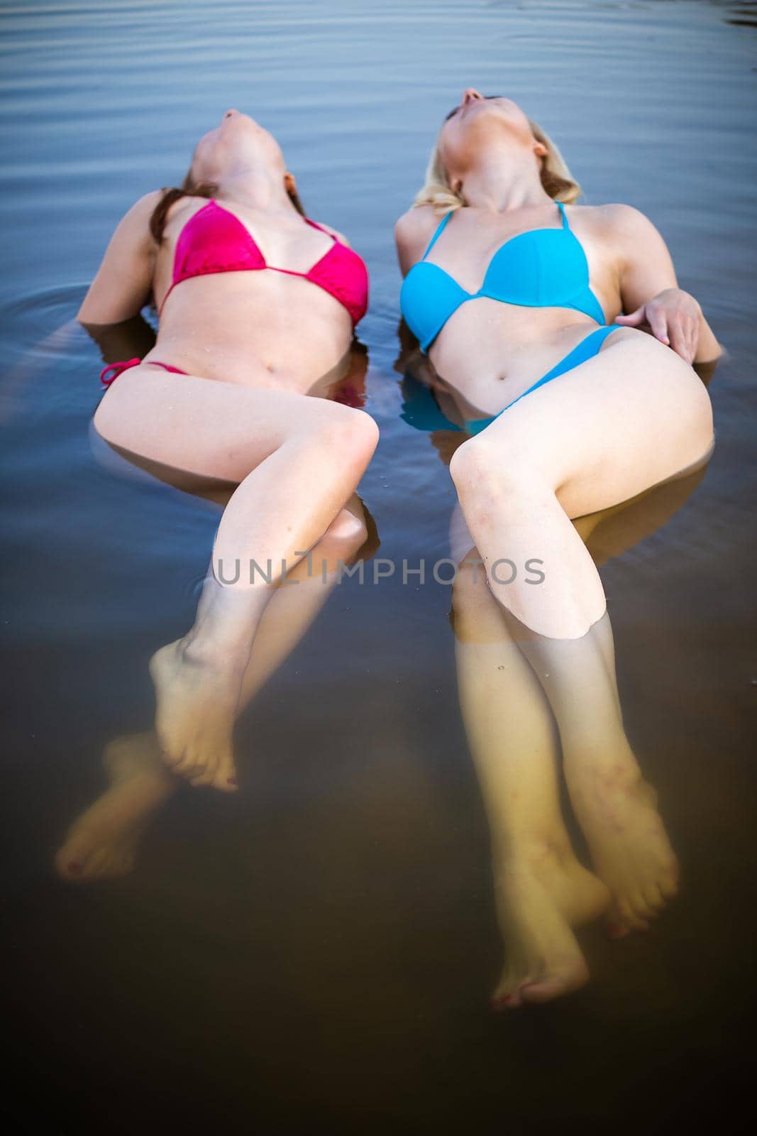 Front view of two young women with beautiful bodies in bikinis. by Evgenii_Leontev