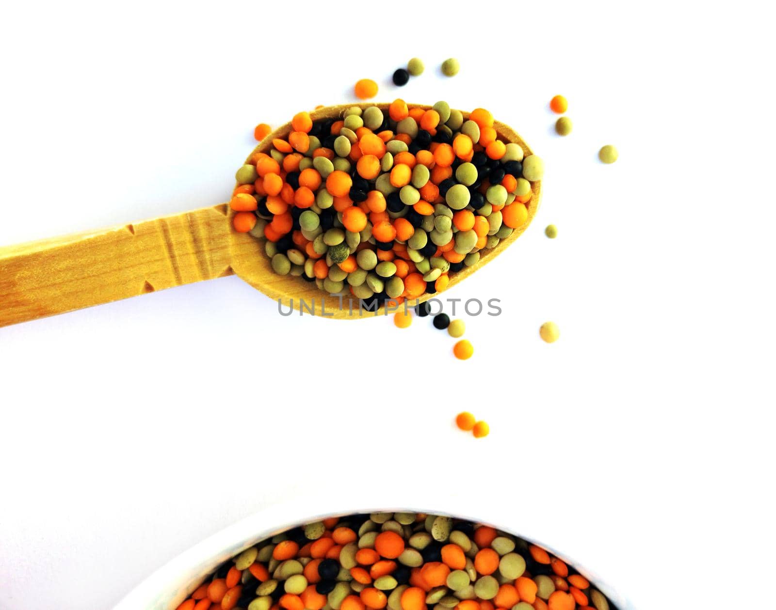 Various lentils mix on wooden spoon over a white background