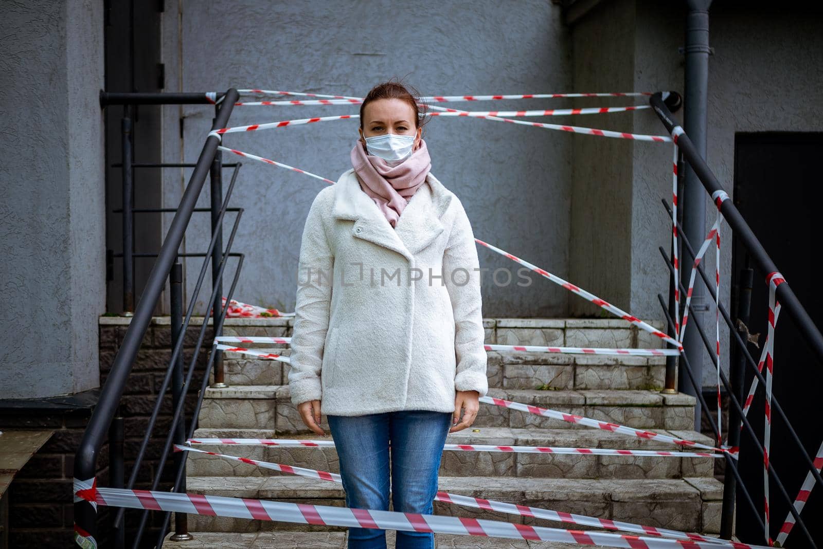 Photo of a girl in a mask. Standing on the street with danger warning tapes. isolated Covid-19 pandemic.