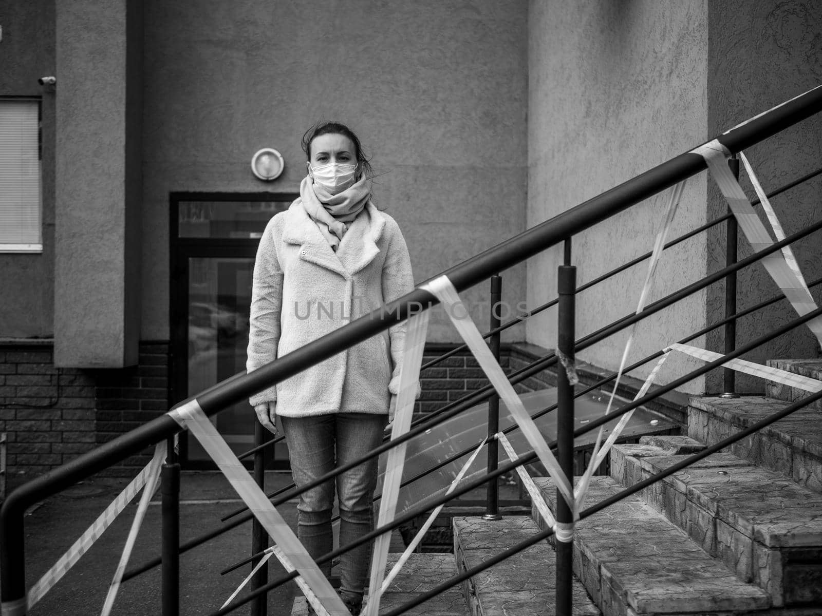 Photo of a girl in a mask. Standing on the street with danger warning tapes. isolated Covid-19 pandemic.