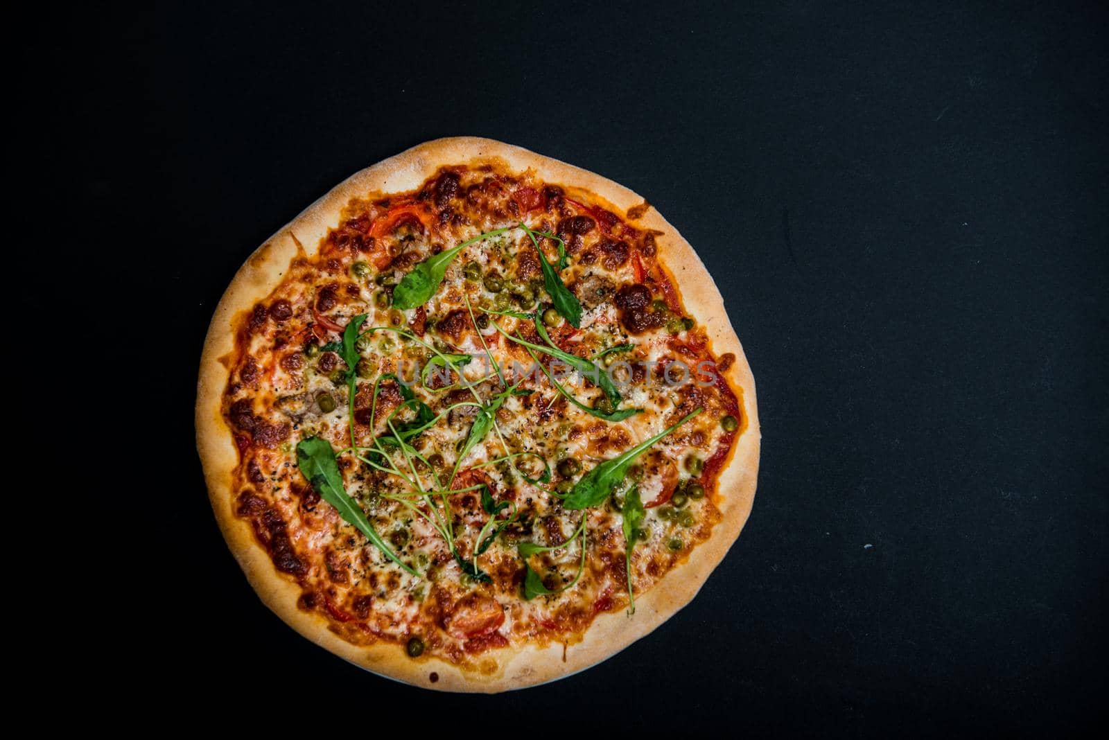 Italian pizza with greens on the black table with copy space by marynkin