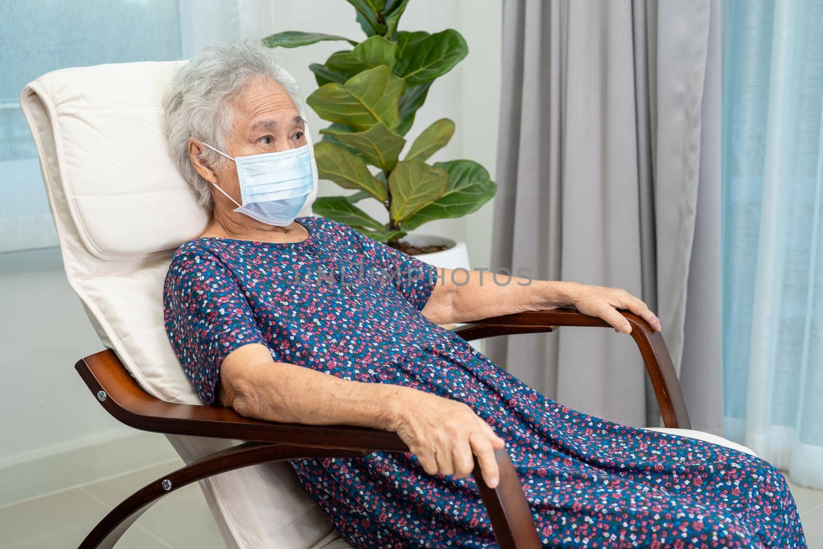 Asian elderly woman sitting and relaxing with happy in rocking chair at room in home. by pamai