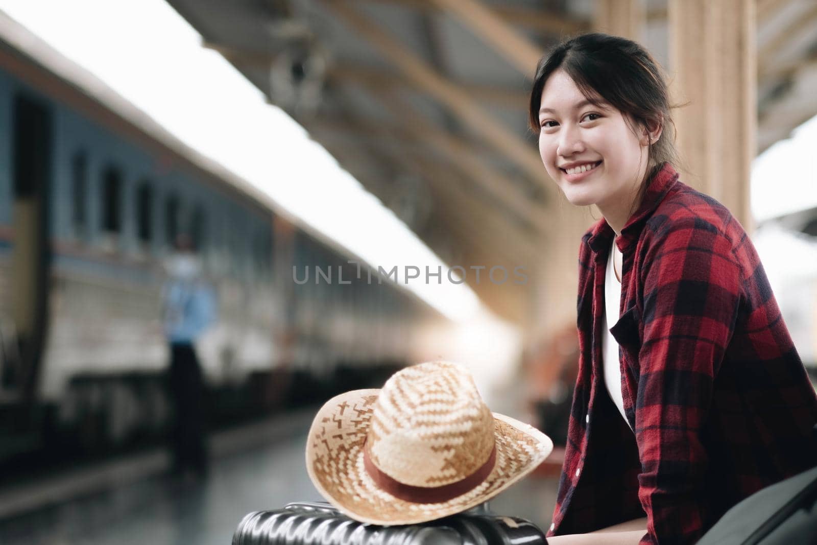 Young traveler woman looking for friend planning trip at train station. Summer and travel lifestyle concept.