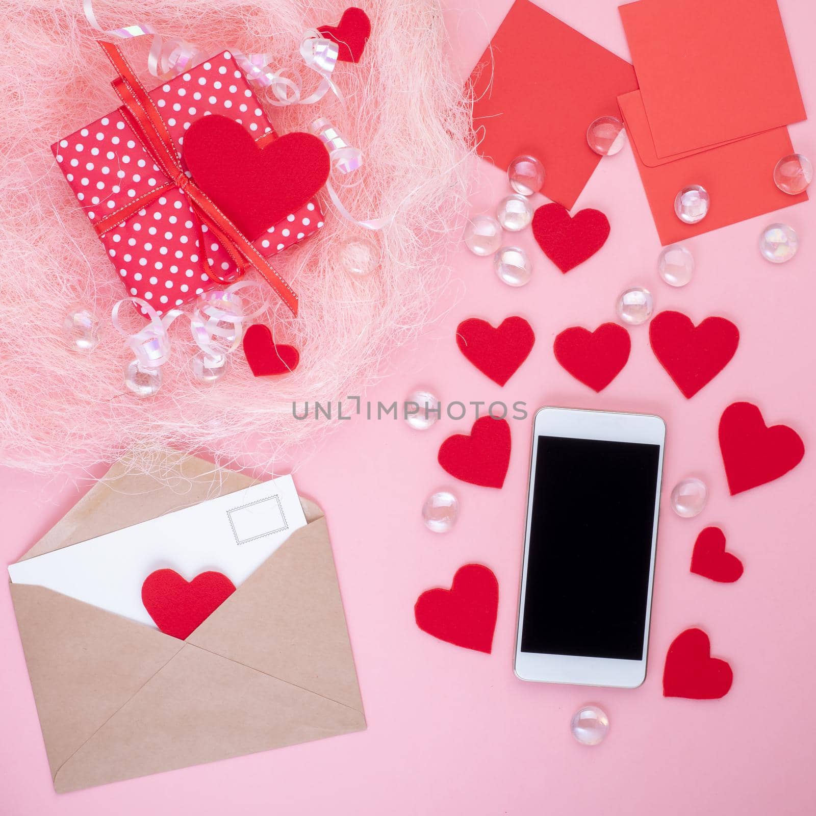 gift in red gift box with bow, smart phone, envelope, card, red heart, pink background, top view, copy space by NataBene
