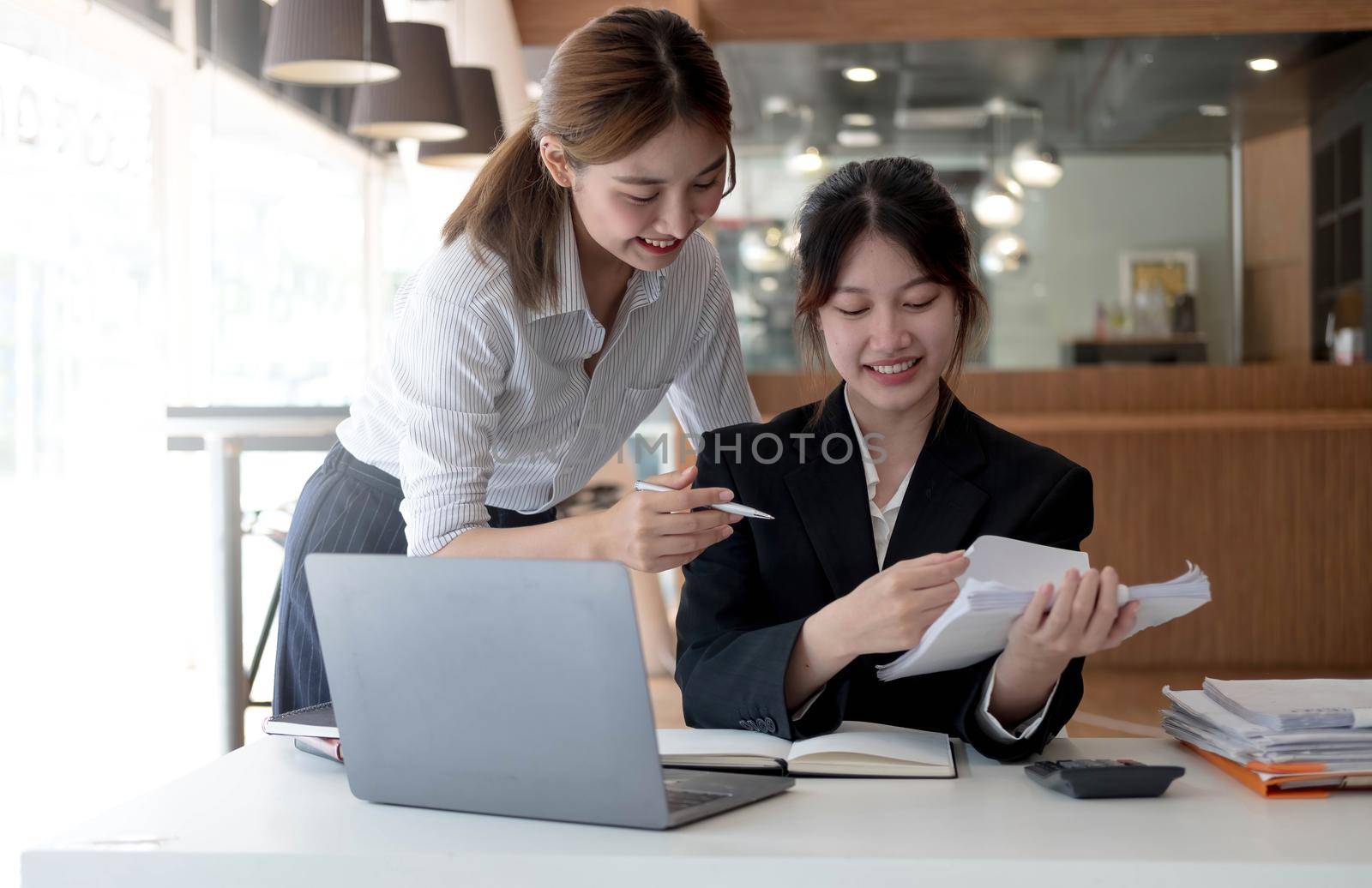 Two young asia business woman working together in office space.