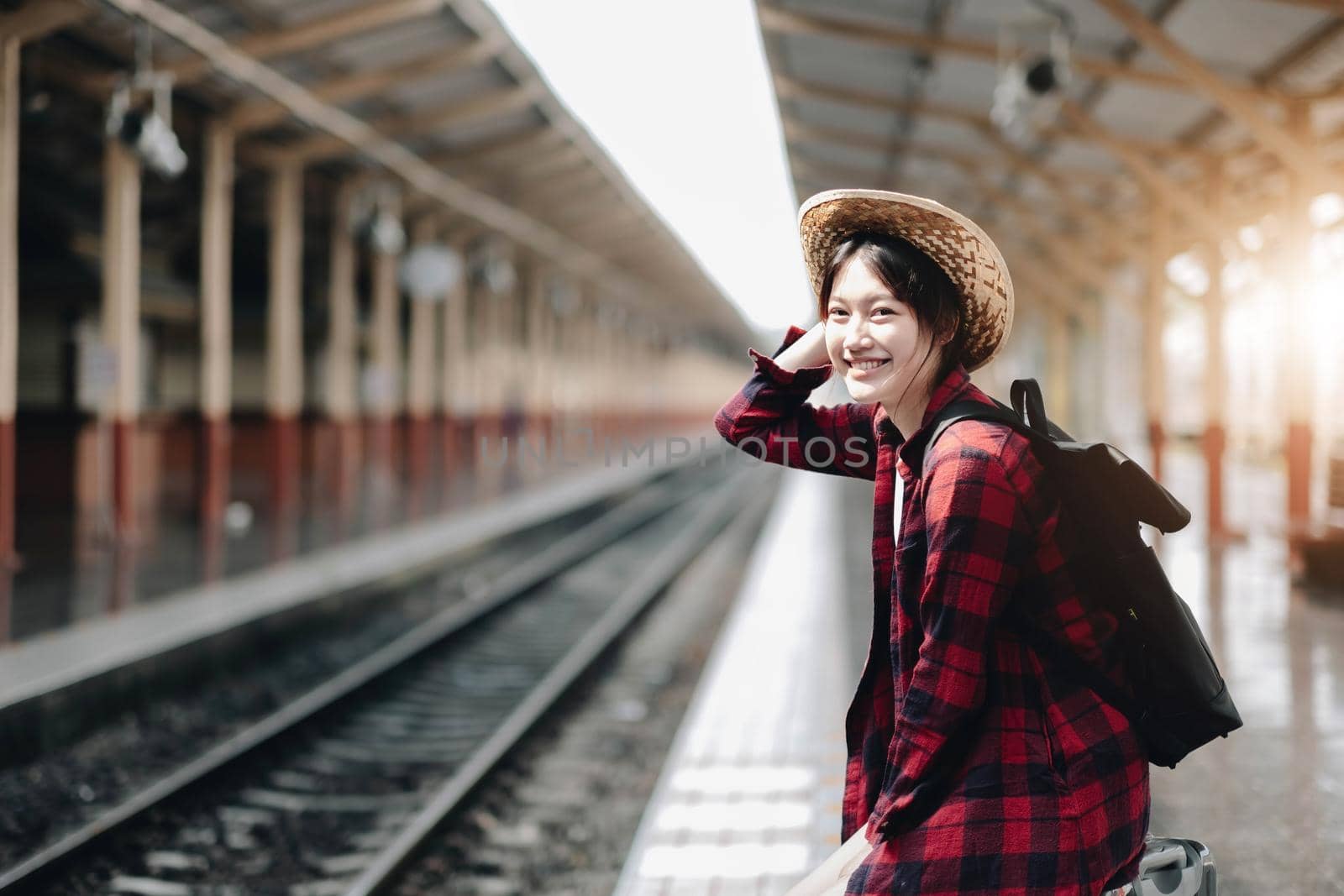 Young traveler woman looking for friend planning trip at train station. Summer and travel lifestyle concept by wichayada