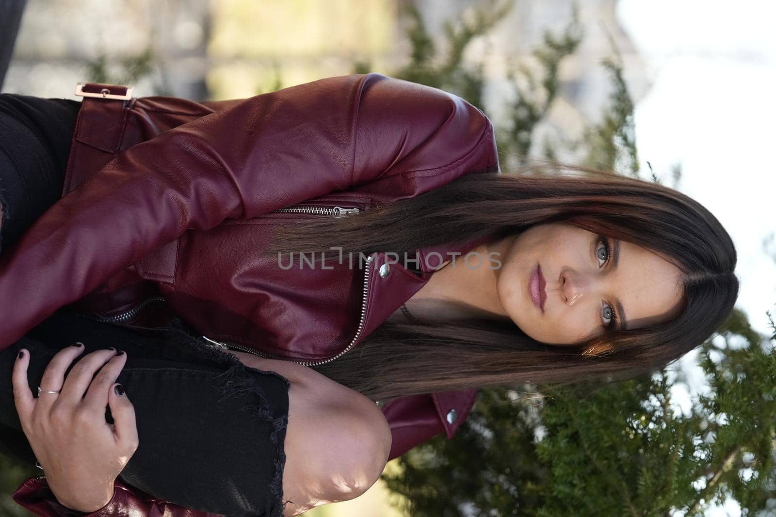 A gorgeous brunette model poses outdoors while enjoying the autumn weather