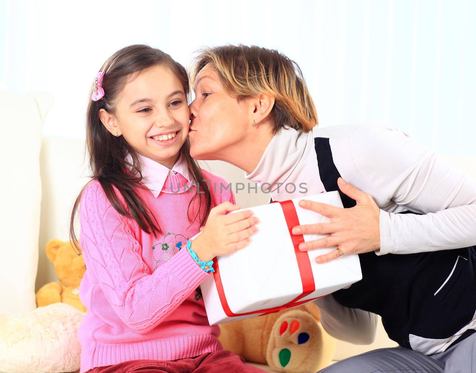 Little beautiful pretty girl giving a gift to her happy mother