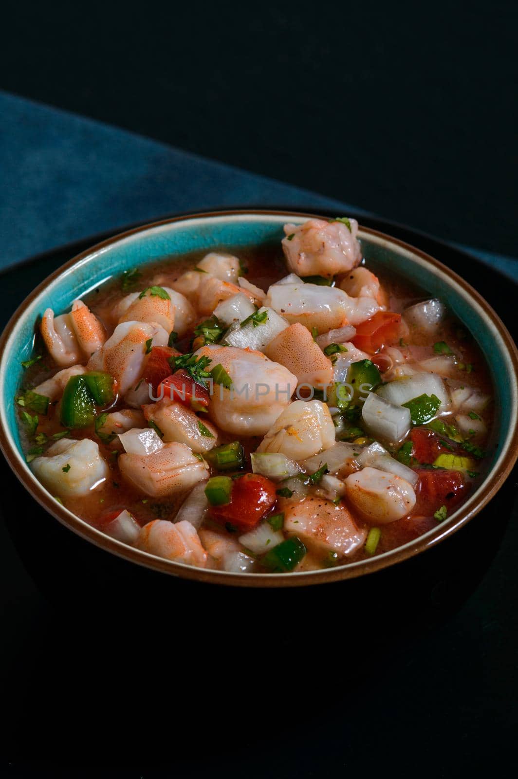 Red shrimp ceviche. Mexican food. Low key lighting on black and blue background