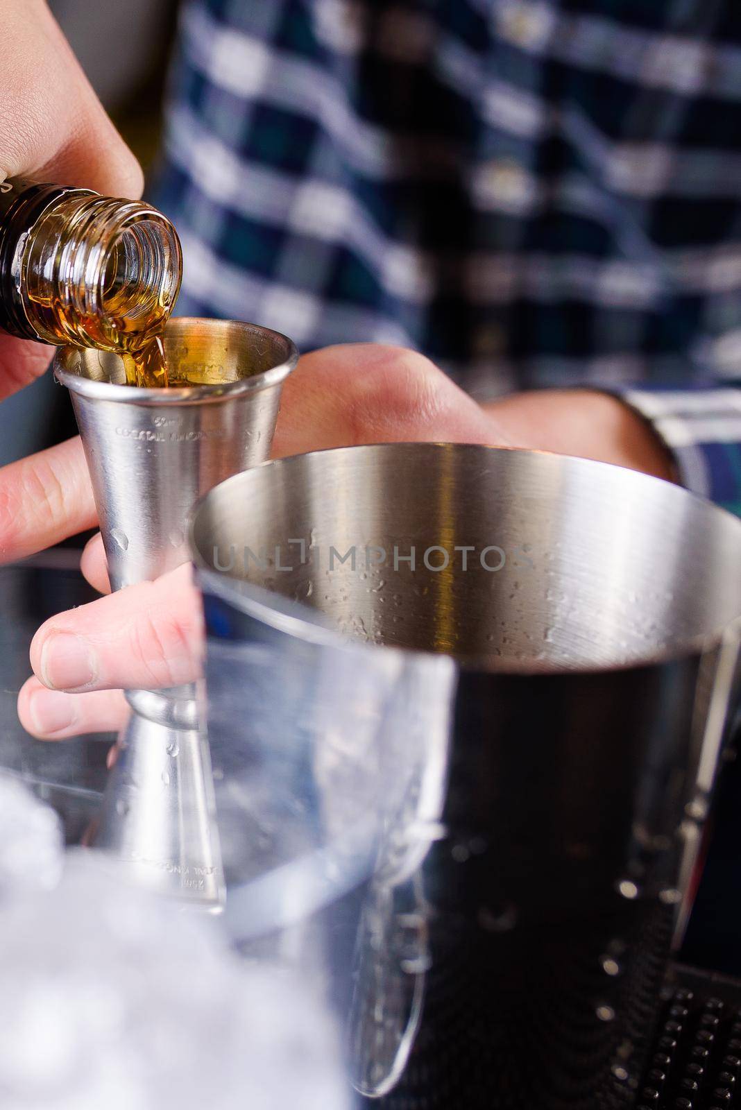 Expert barman is making cocktail at night club, Barman holds a cocktail in his hand. No face. Selective focus. by Rabizo