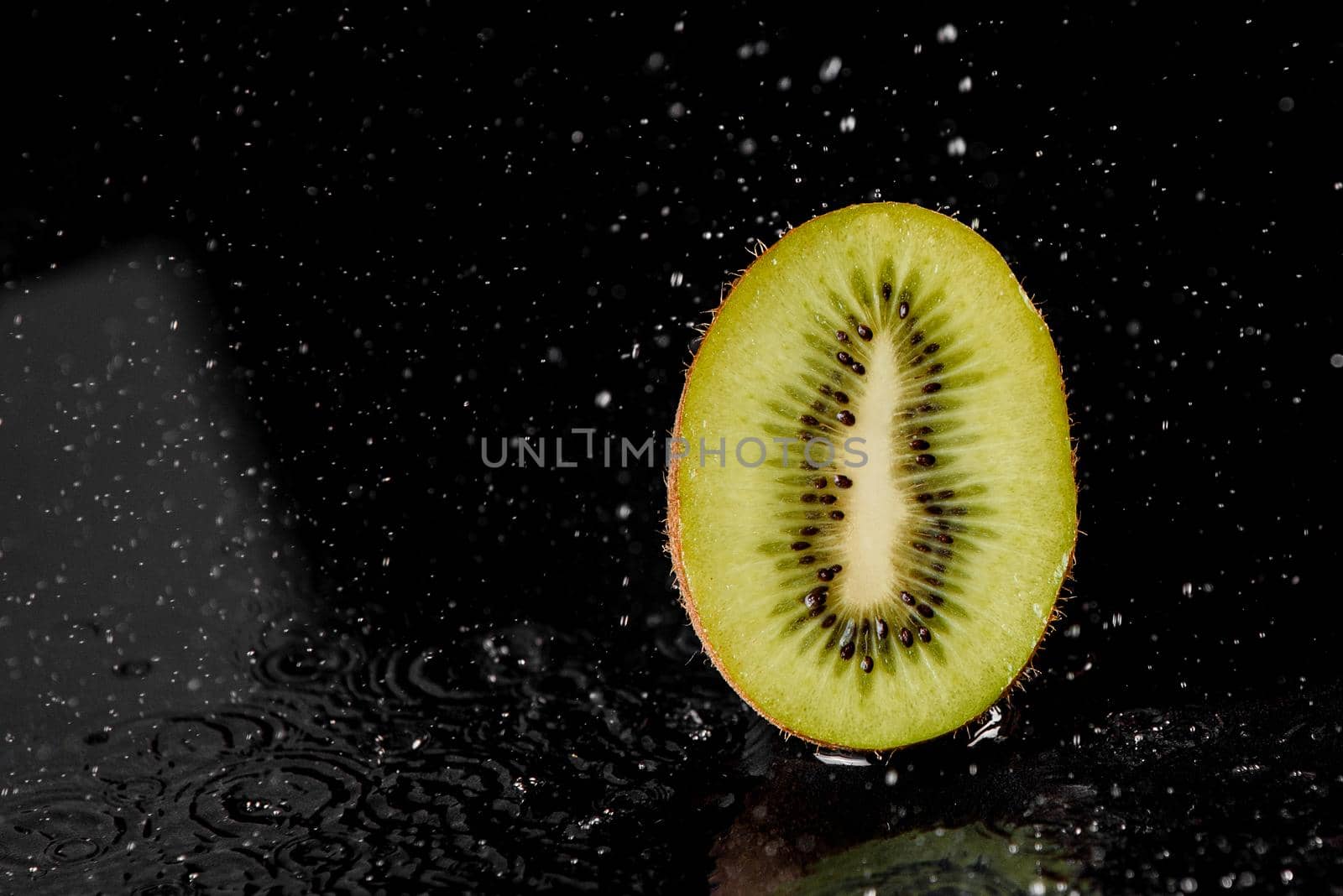 Kiwi with splashing water on black background. Citrus fruit with water drops. Healthy freshness food. Green fruit with vitamin. by Rabizo