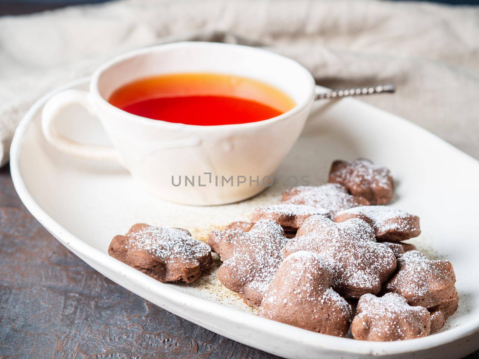 Winter holiday composition, side view, copy space, gray blue background. Tea, flax cookies with cinnamon.