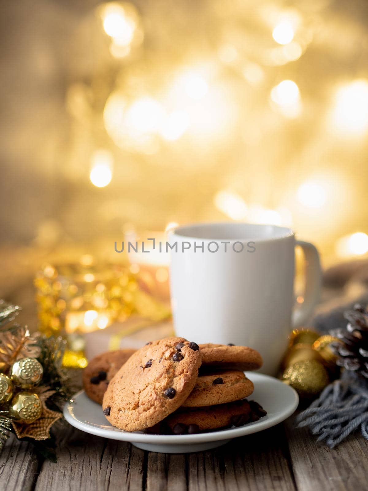 Christmas background with Chocolate chip cookies, cup of tea. Cozy evening, mug of drink, Christmas decorations, candles and lights garlands.