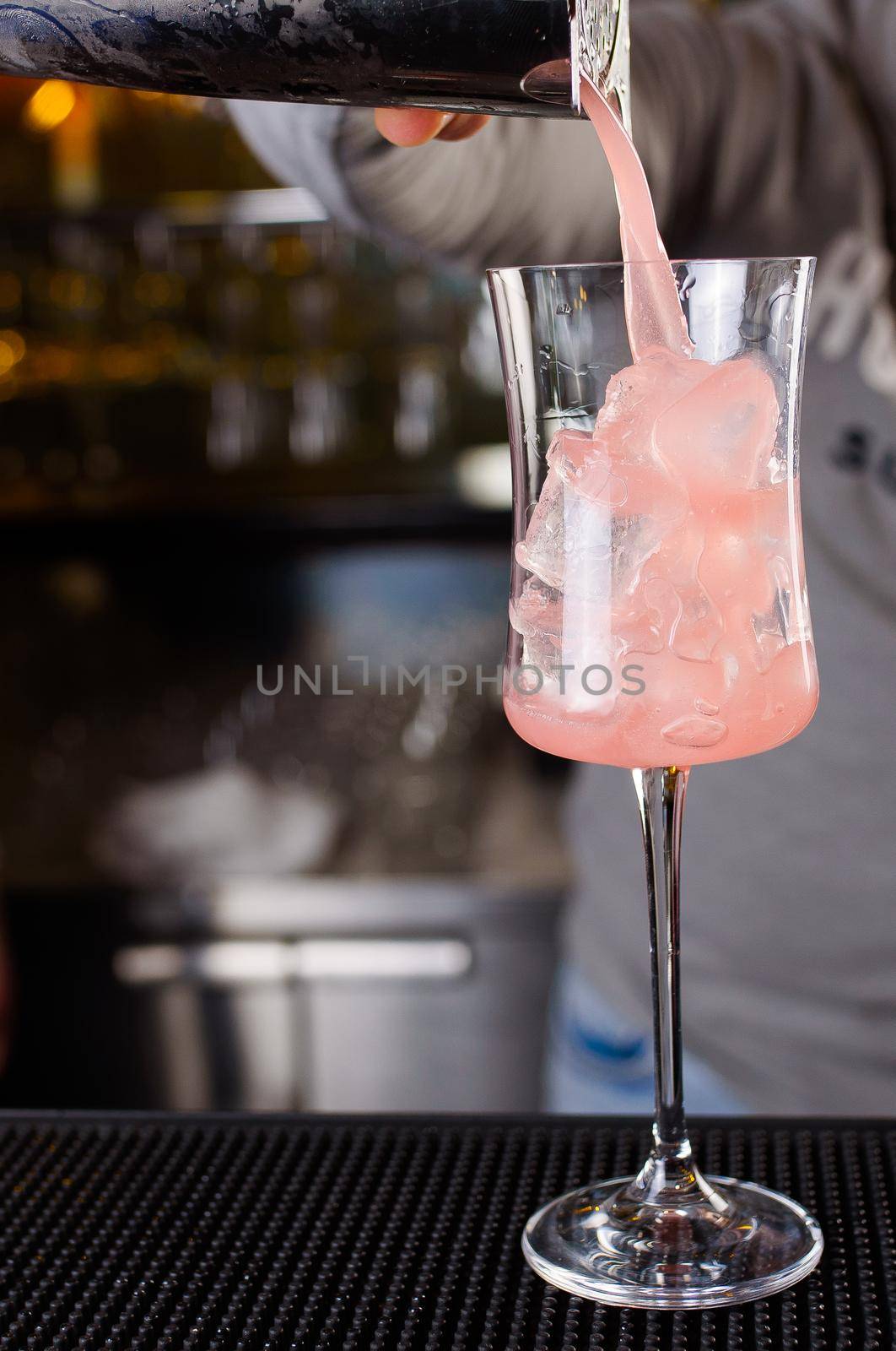 Expert barman is making cocktail at night club, Barman holds a cocktail in his hand. No face. Selective focus