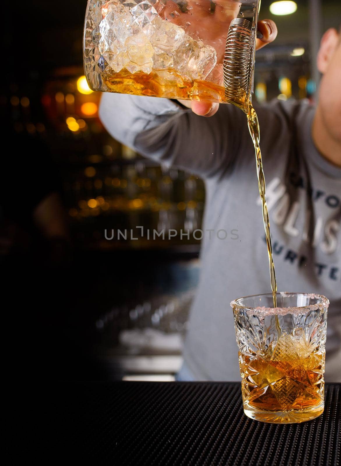 Expert barman is making cocktail at night club, Barman holds a cocktail in his hand. No face. Selective focus