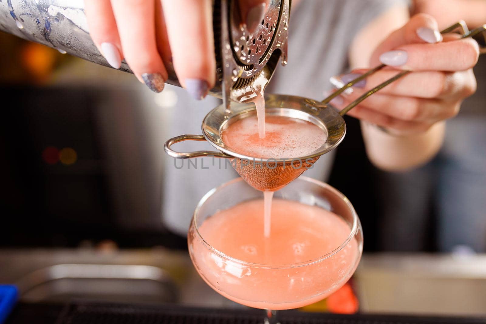 Expert barman is making cocktail at night club, Barman holds a cocktail in his hand. No face. Selective focus. by Rabizo