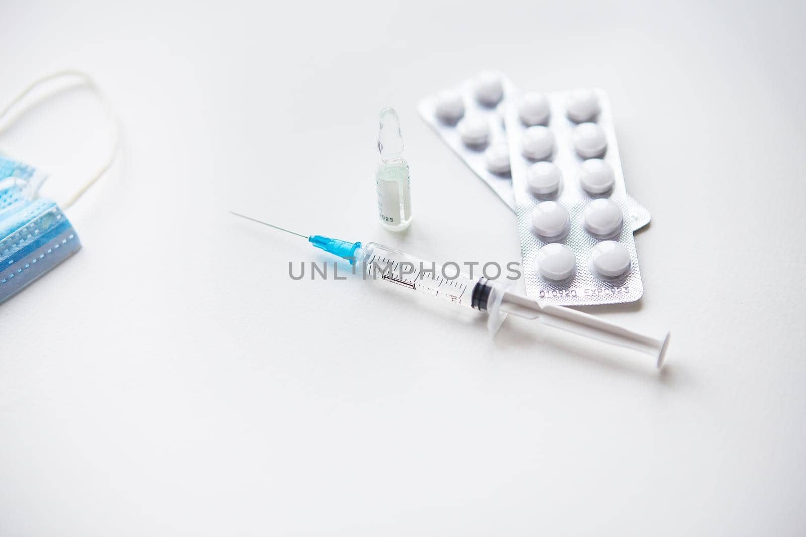 Preparation for vaccination against covid-19. Syringe, vaccine, pills, medical mask. by sfinks