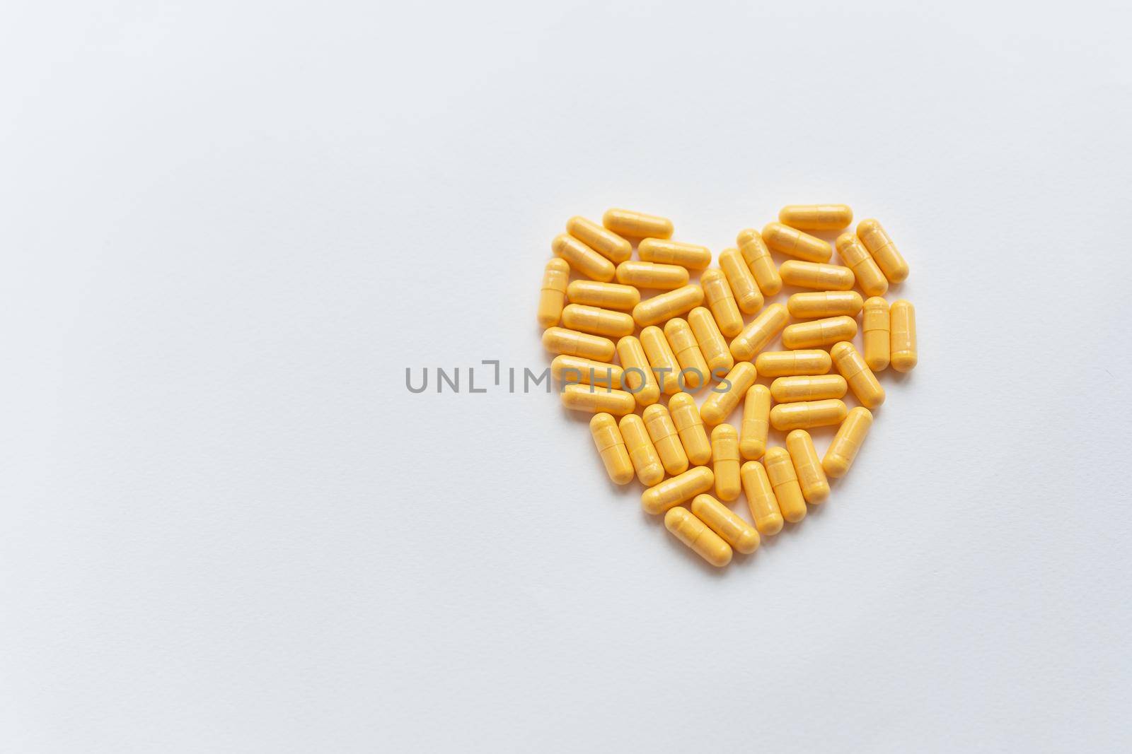 Heart shaped yellow pills, health and heart problems. Medicine and healthcare concept. Place for an inscription