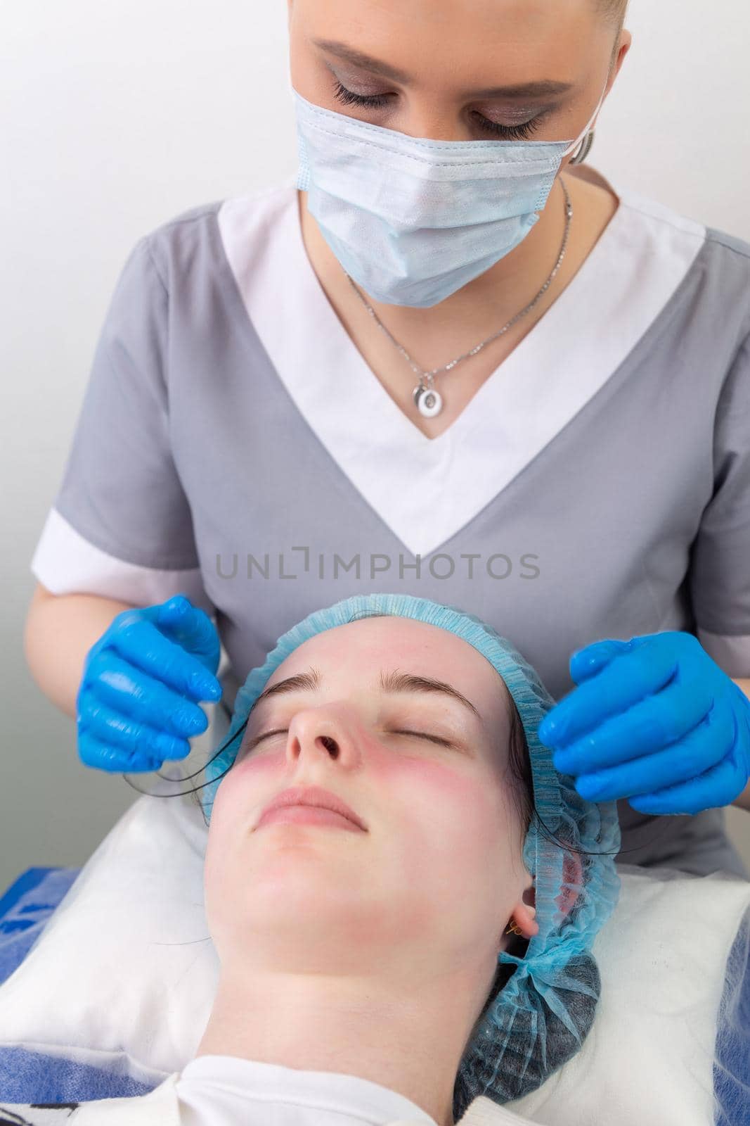 A female cosmetologist manually treats the patient's skin with a moisturizing and toning gel. The procedure helps to control the balance of fat content, restores the pH balance of the skin, gives a feeling of freshness and softness.