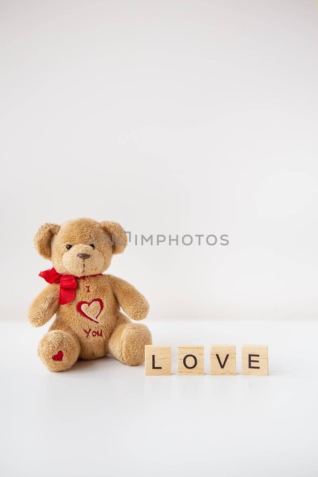 Valentine's day teddy bear and wooden letters with the inscription love. Place for an inscription. by sfinks