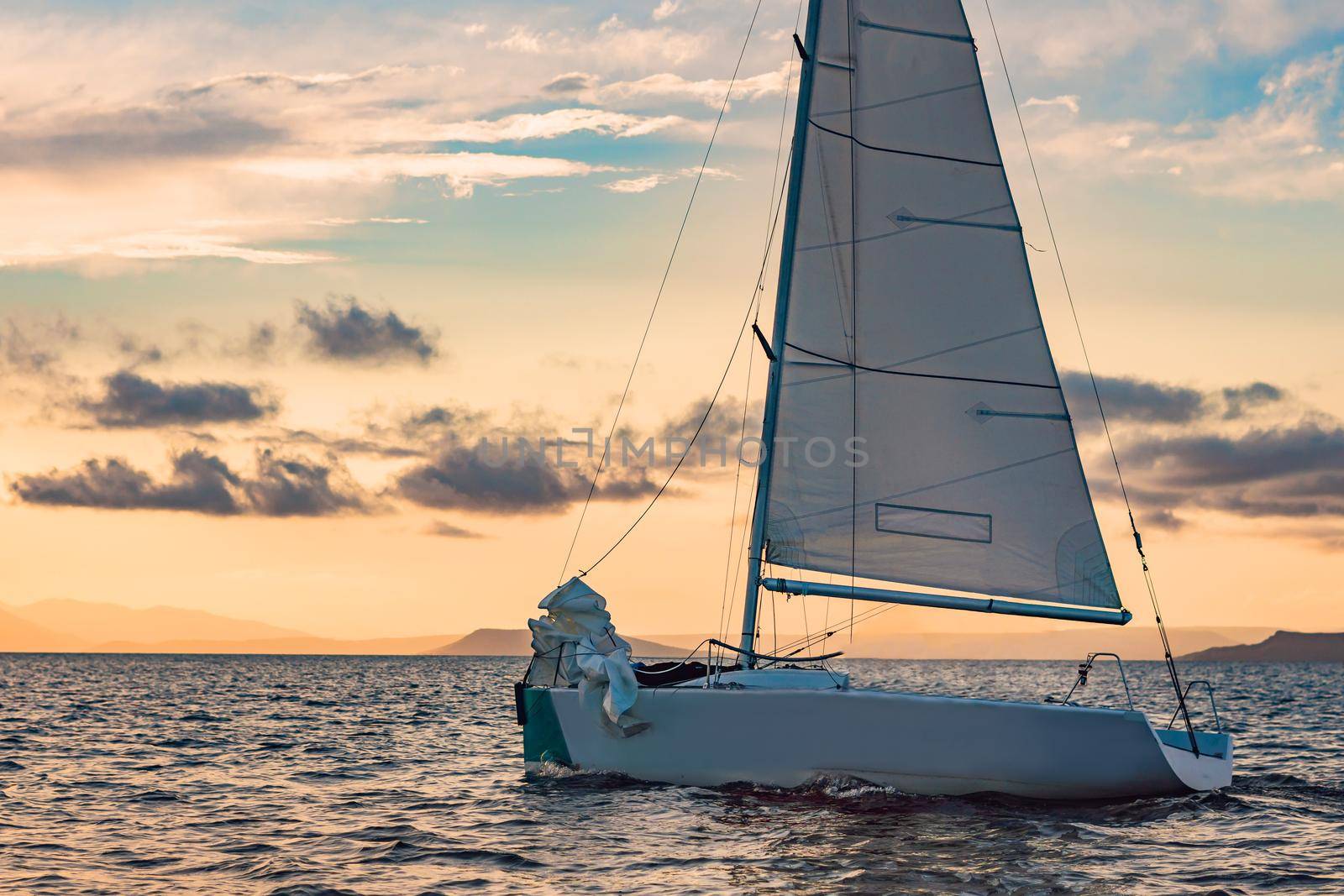 Sailboats on the background of the sunset over the sea.