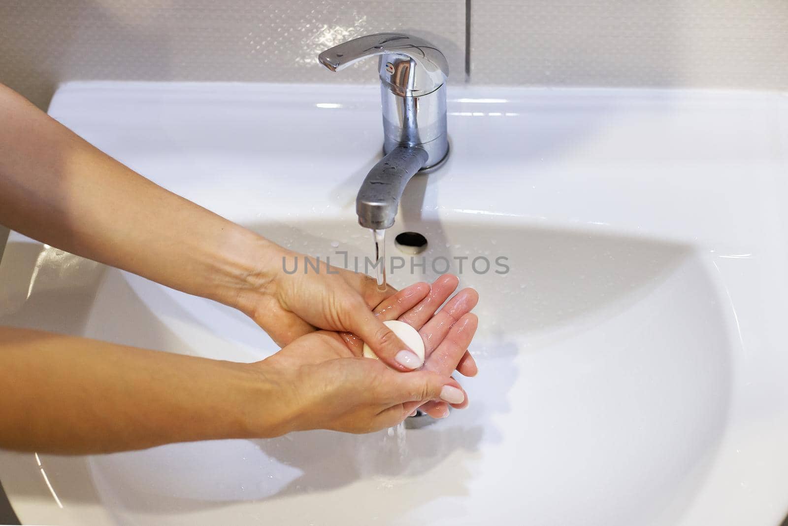 Washing hands with soap and water under the tap, close-up. Daily hygiene. by sfinks