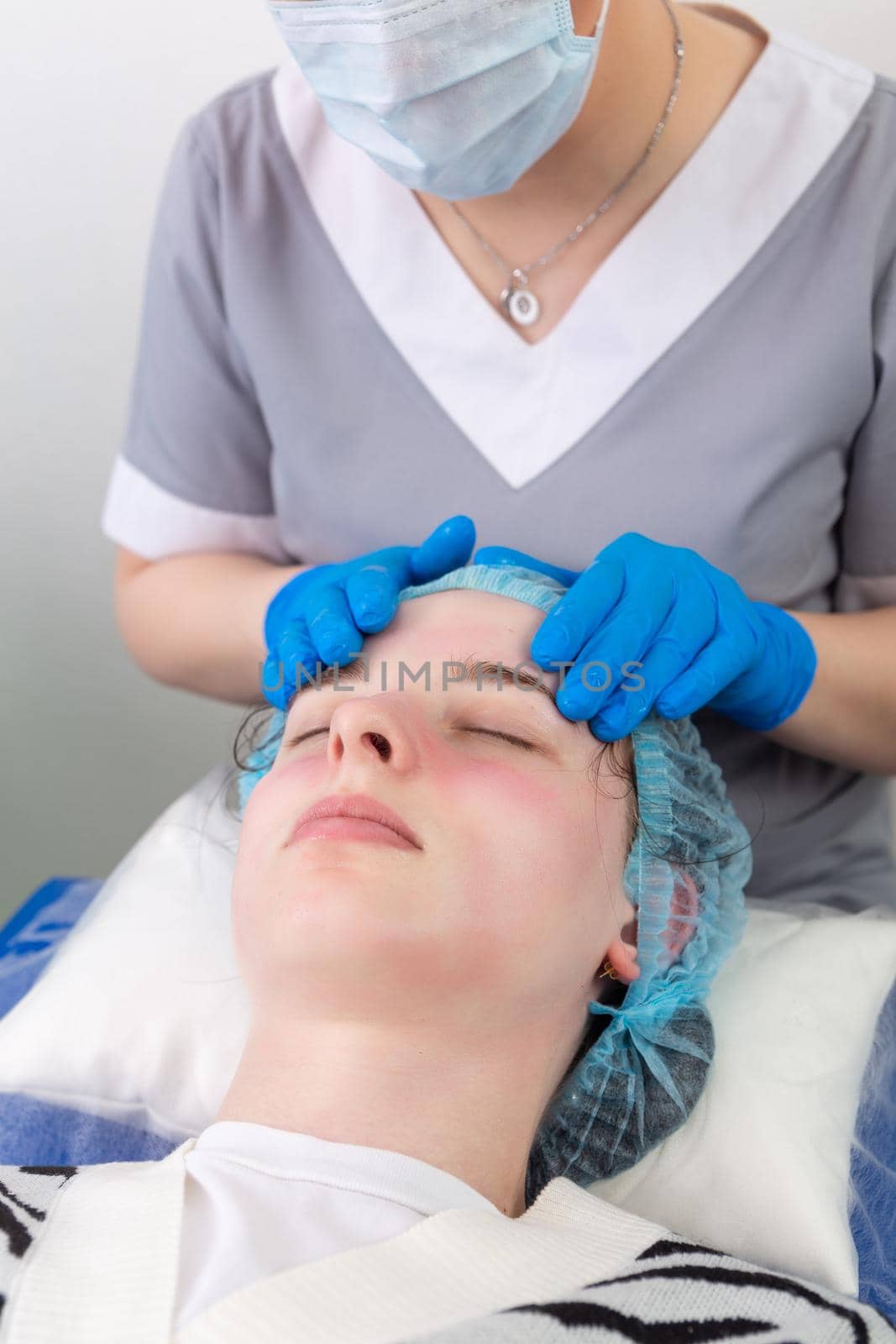 A female cosmetologist manually treats the patient's skin with a moisturizing and toning gel. The procedure helps to control the balance of fat content, restores the pH balance of the skin, gives a feeling of freshness and softness.