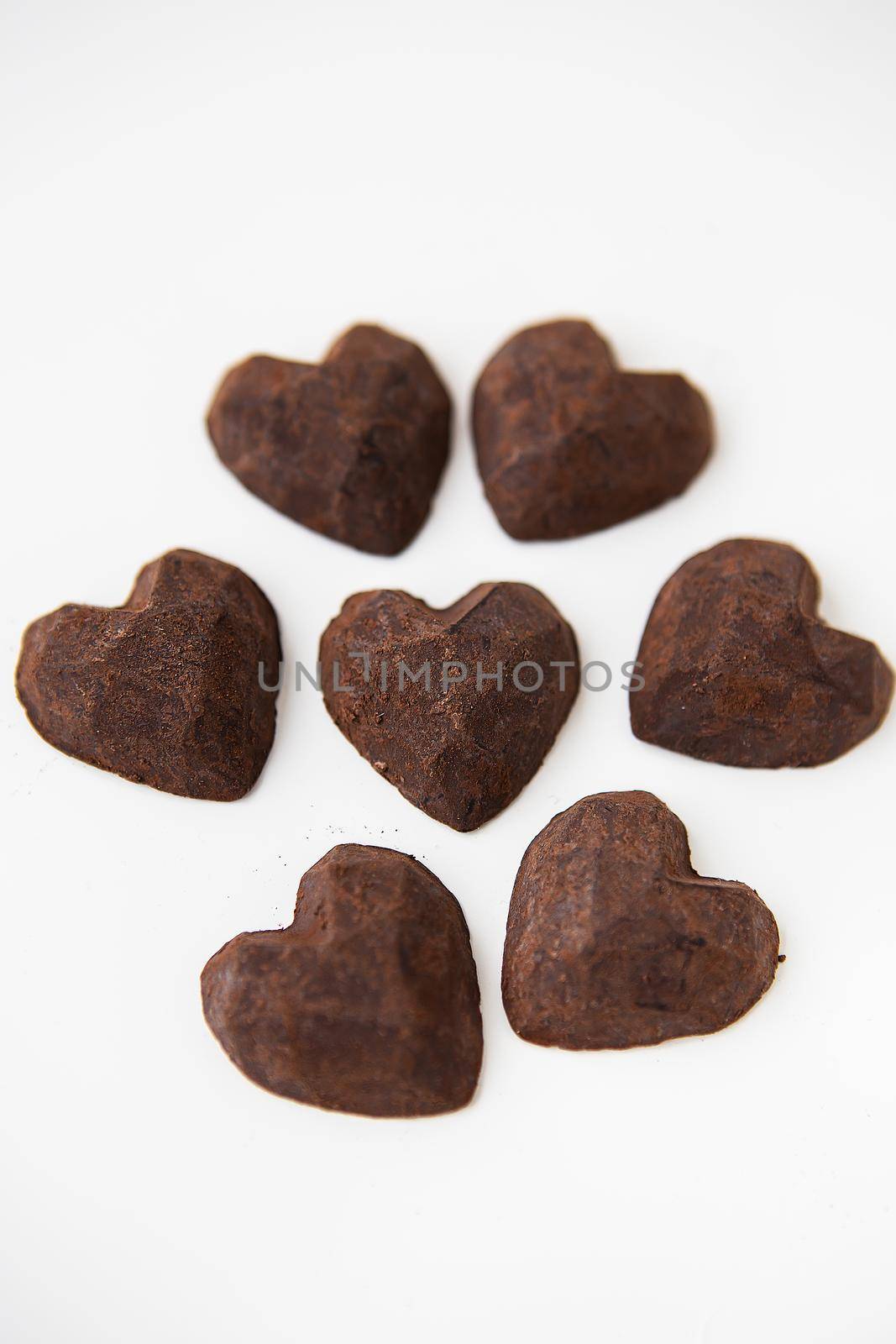 Truffle chocolate candies in the form of a heart on a white background. by sfinks