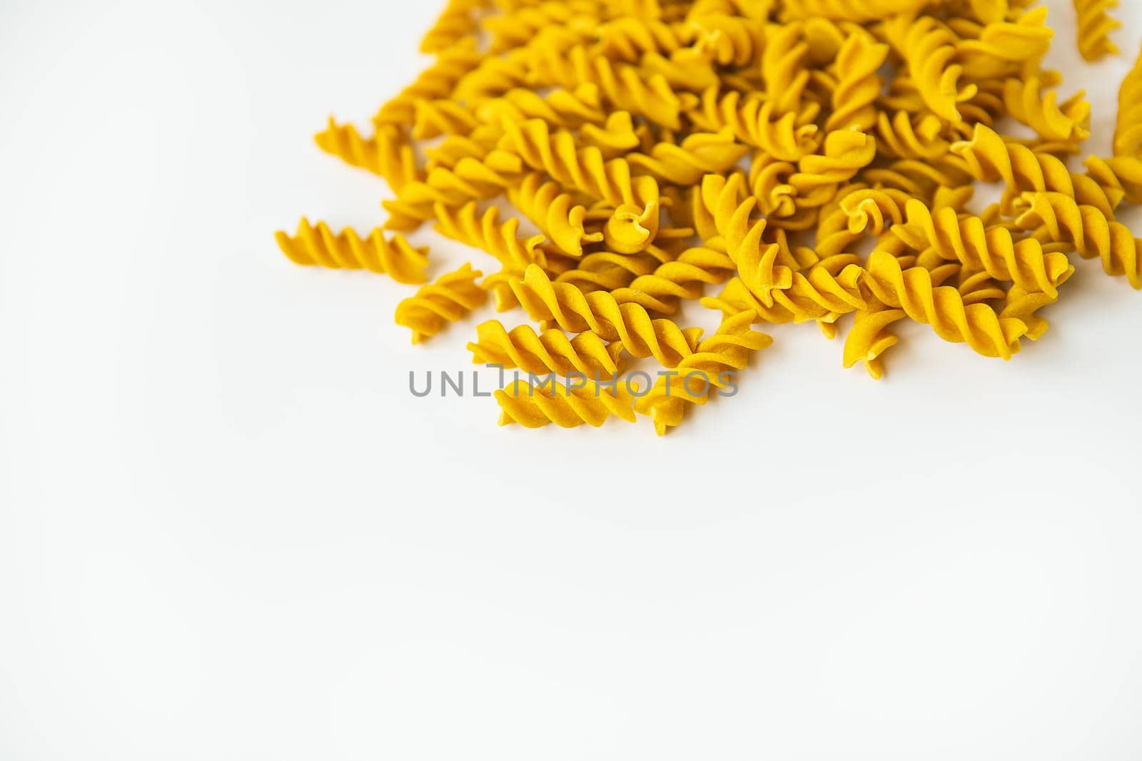 Fusilli pasta close-up on a white plate. Natural pasta made from hard wheat with the addition of pumpkin. by sfinks