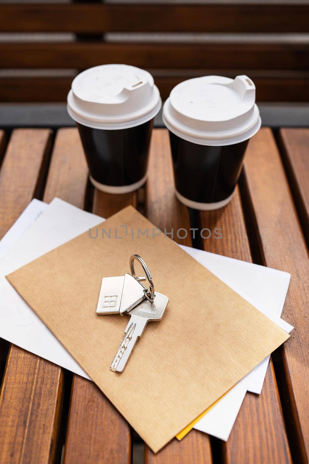 Coffee break - two cups in a plastic cup. Real estate, keys from the tenant from an apartment or house, purchase and sale of real estate. Mortgage for the purchase of an apartment