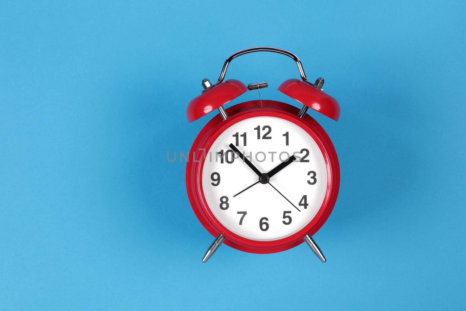 A retro red clock on a blue background