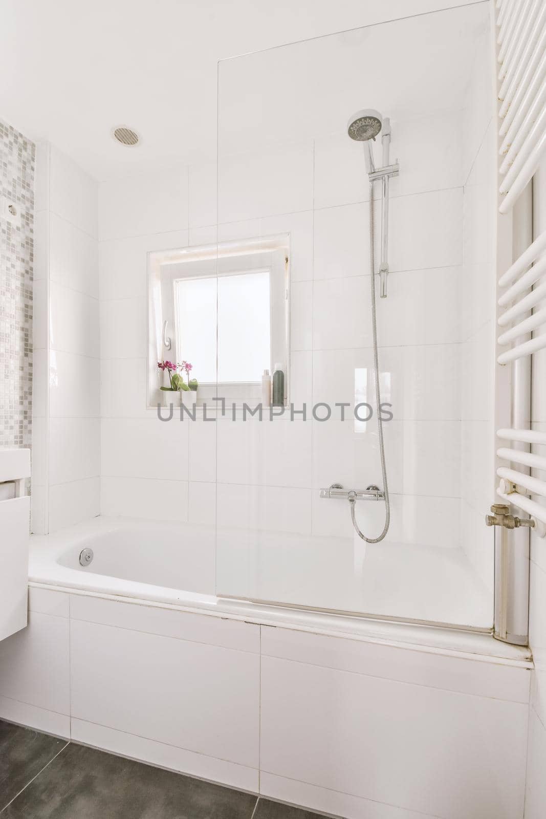 Bathtub with shower near small window by casamedia