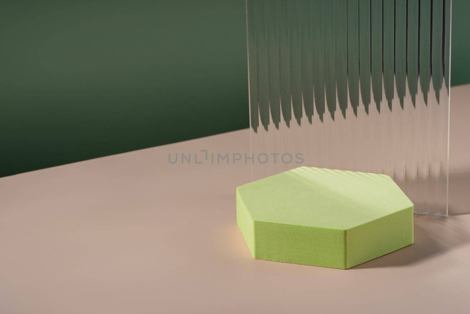 Acrylic ribbed plate, hexagon podium, background for cosmetic product packaging on green backdrop. Showcase for jewellery presentation, display for perfume advertising, cosmetics branding scene by photolime