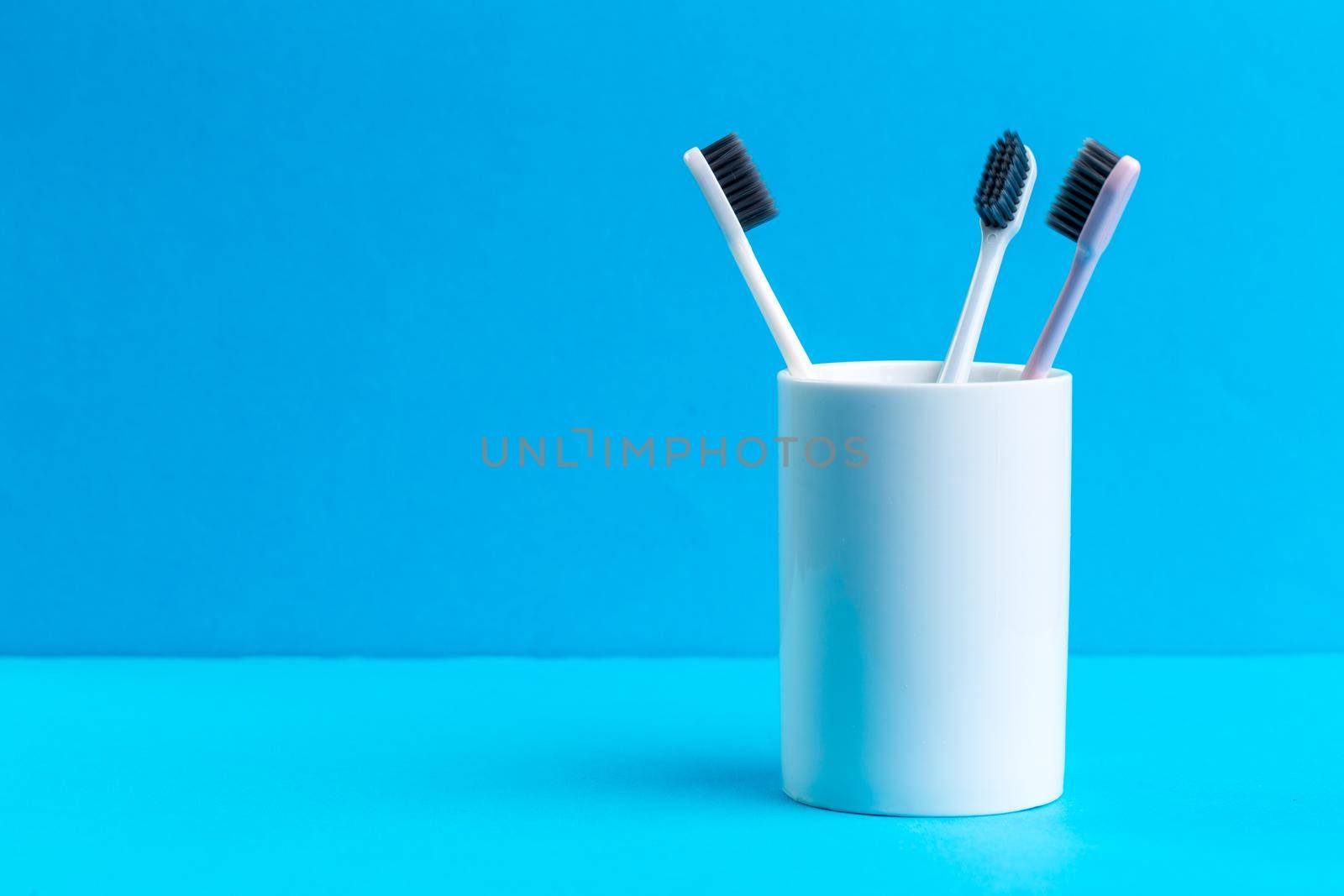 Toothbrushes in glass on the table