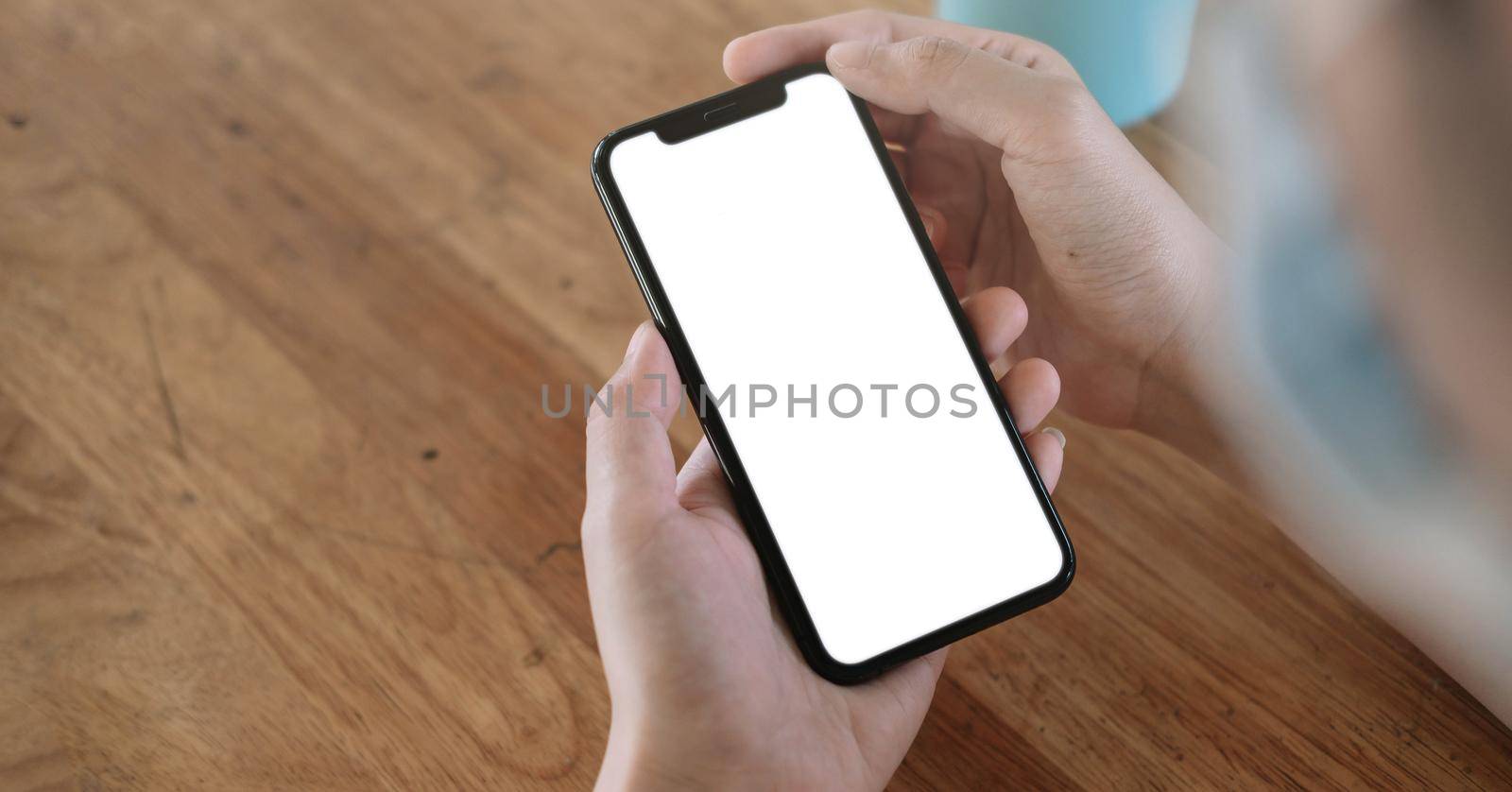 Top view Woman sitting and holding blank screen mock up mobile phone.