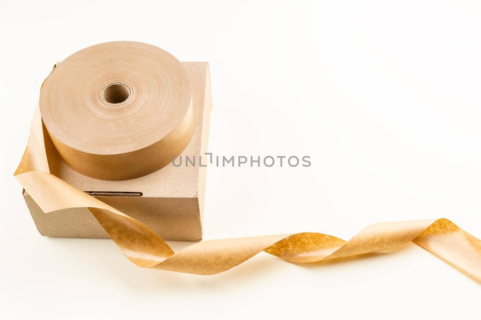 Biodegradable eco friendly paper sticky tape roll on the cardboard box. Zero Waste packaging