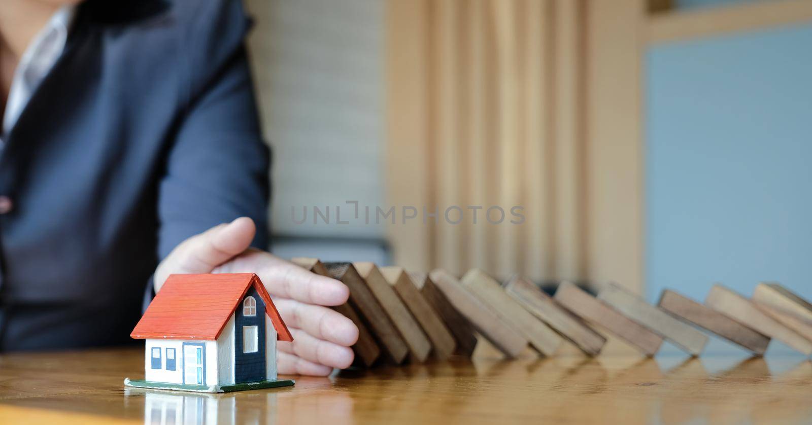 Protect the house from falling over the wooden blocks, Insurance and risk concept