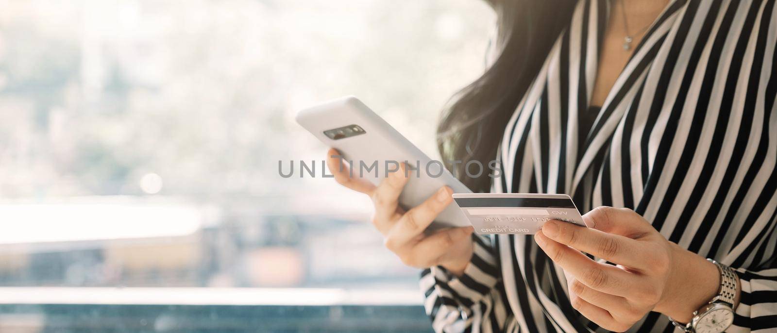 close up woman holding smartphone with credit card for pay online shopping e-commerce online payment concept