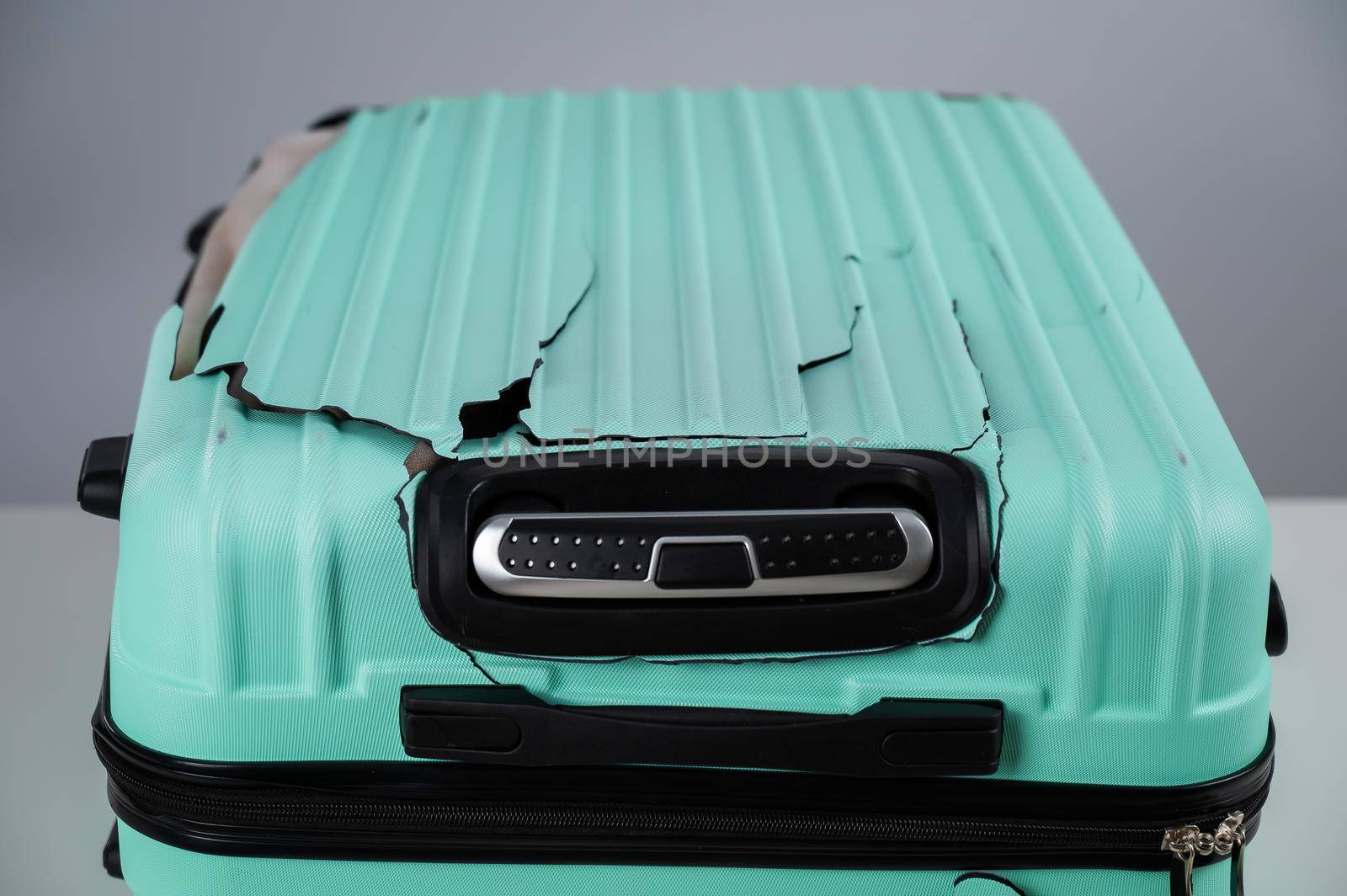 Broken plastic mint suitcase on a white background