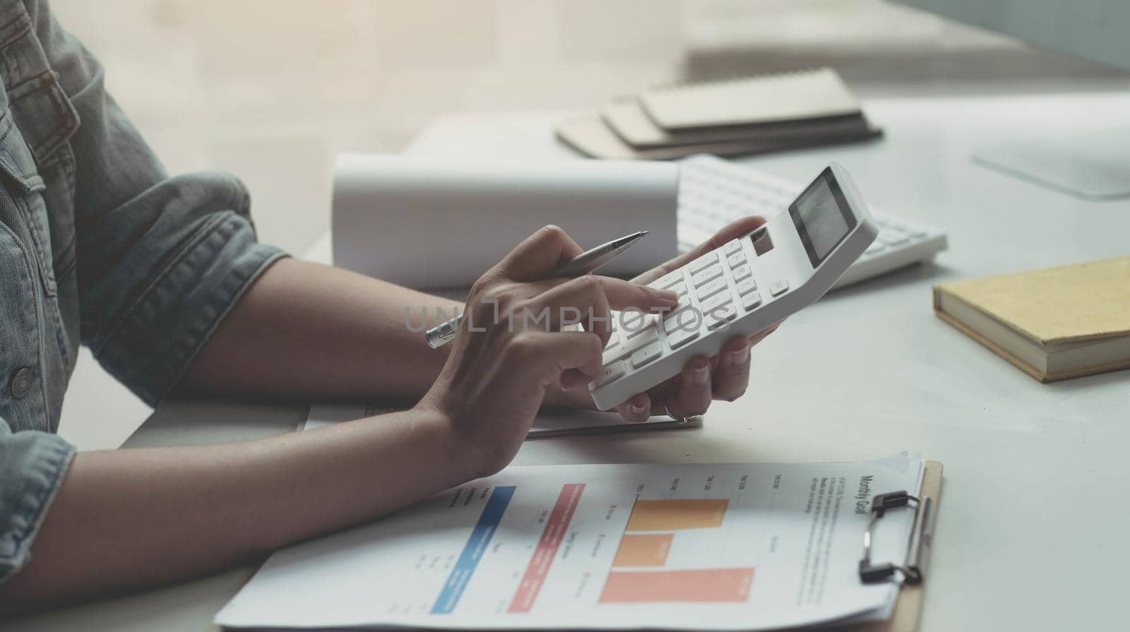 Close up woman working with calculator, business document and laptop computer notebook by wichayada