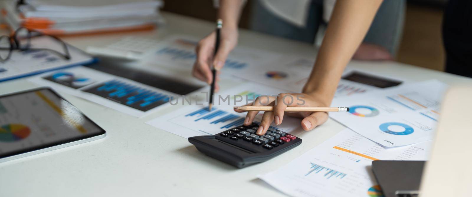 Close up accountant bookkeeper woman working about financial with calculator at his office to calculate expenses, Accounting concept.